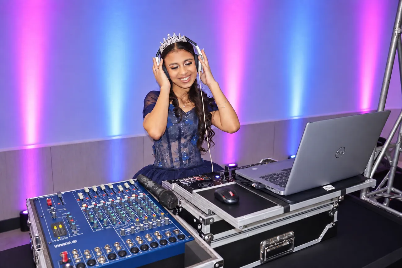 Alice com fones de ouvido na cabine do DJ durante sua festa de 15 anos.