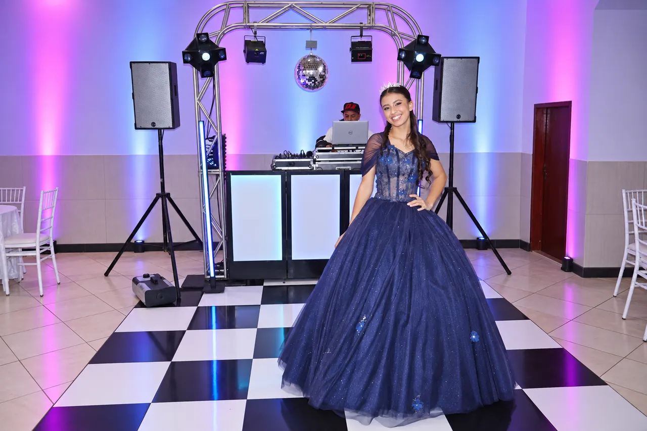 Alice em sua festa de 15 anos diante da estrutura de DJ, som e iluminação da CSOM Eventos.