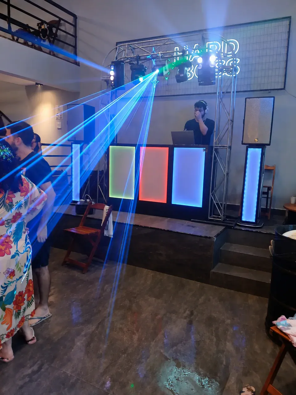 Show de laser azul na pista. Feixes azuis atravessando o salão enquanto o DJ conduz o repertório e a energia dos convidados.