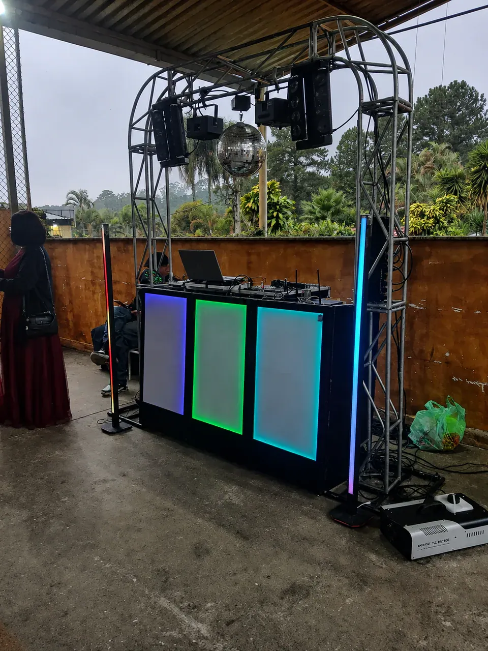 DJ para evento em área coberta. Treliça e cabine instaladas em espaço aberto protegido, com equipamentos preparados para o ambiente.