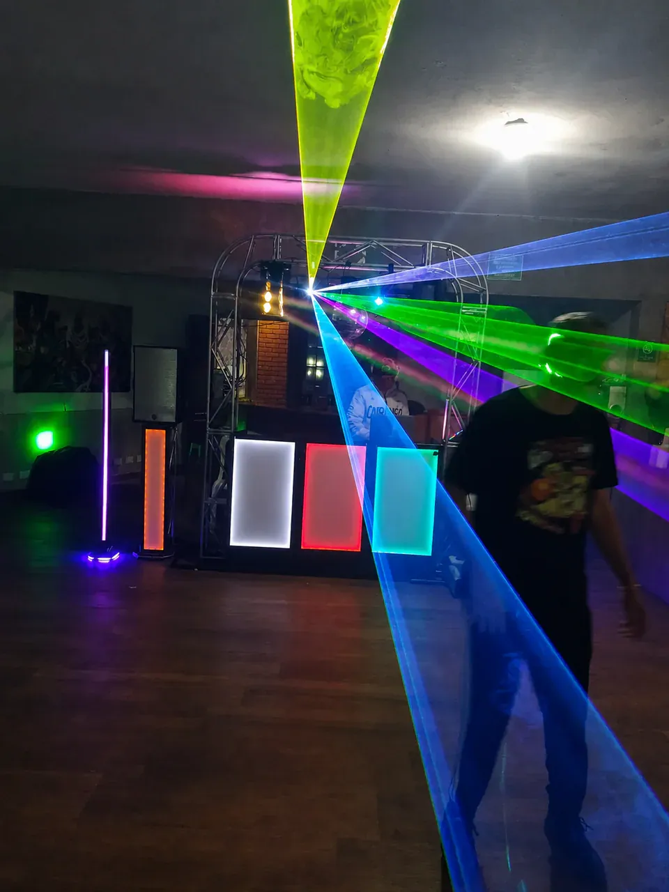 Dark party venue with green, blue and violet laser beams