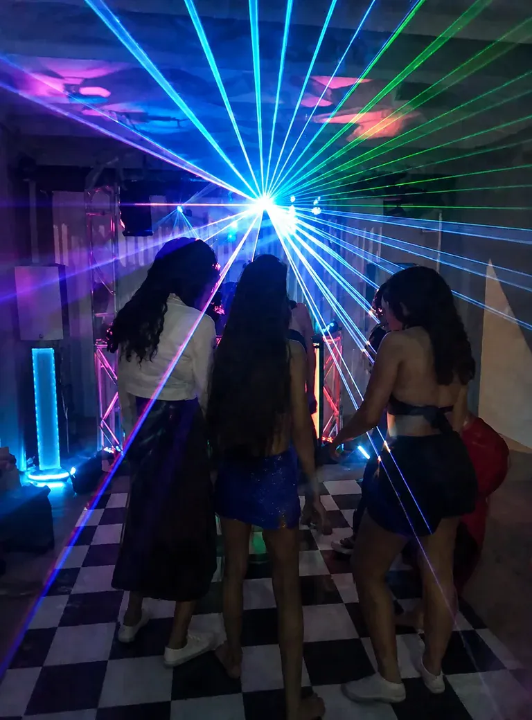 Teenagers dancing at a party with CSOM color laser lighting