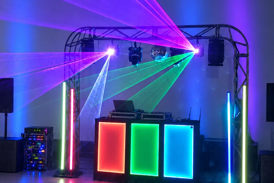 Estrutura de DJ para formatura com barras de LED, globo espelhado e feixes multicoloridos.